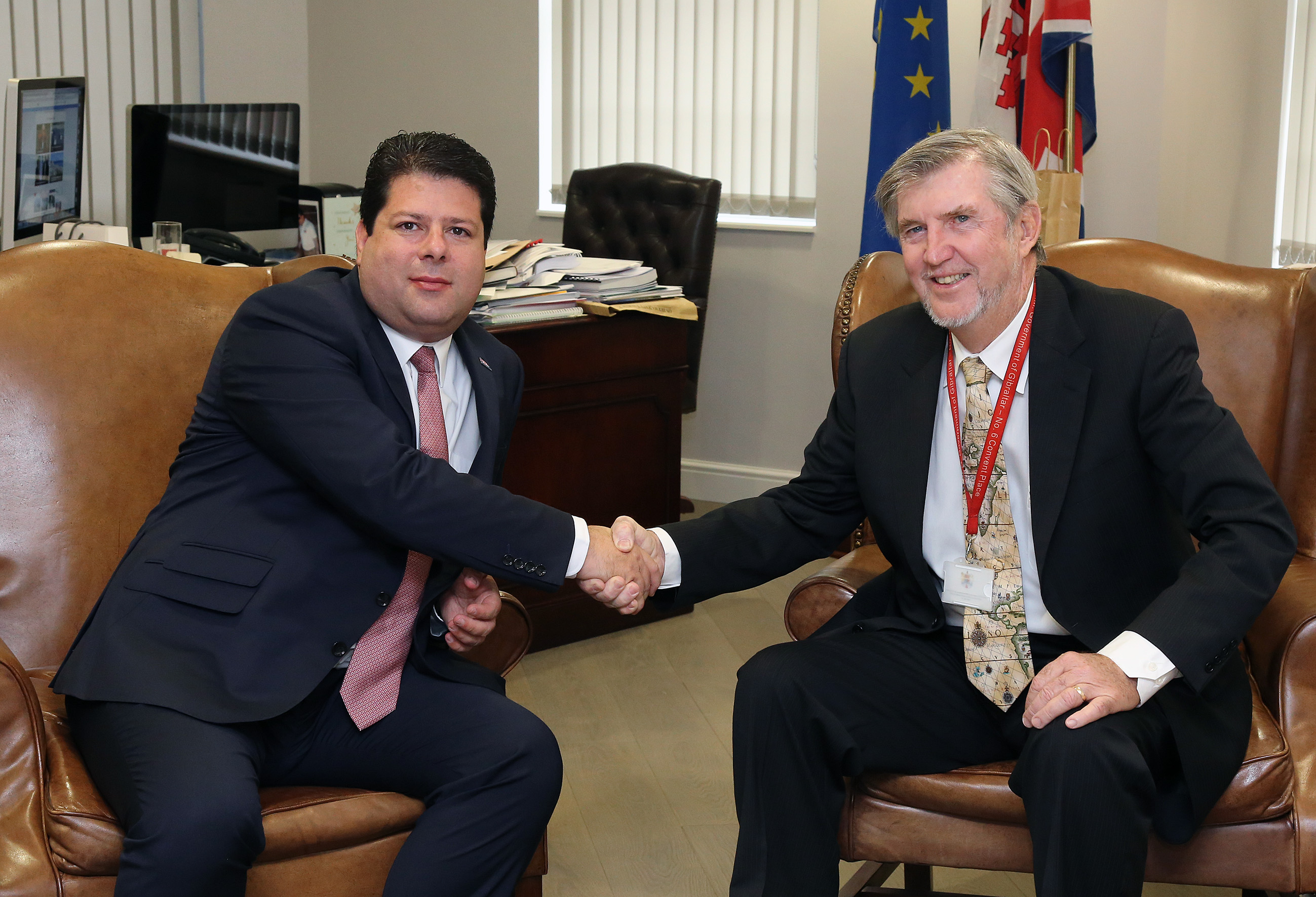 Joe Farrell shakes hands with a politician from Gibraltar