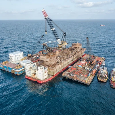 Barge between two floating docks with Resolve boats to the side