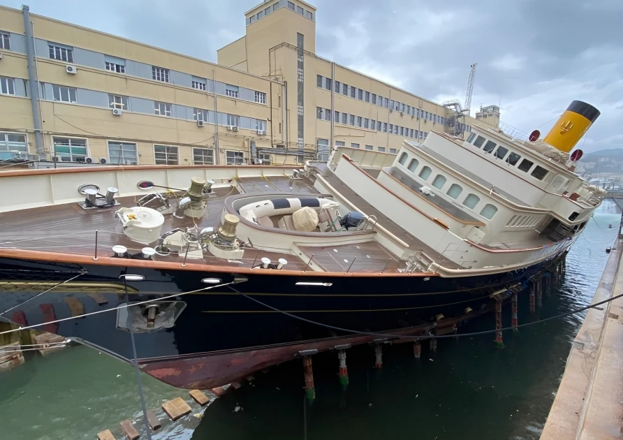 A steamship lies tilted on her side at a dock