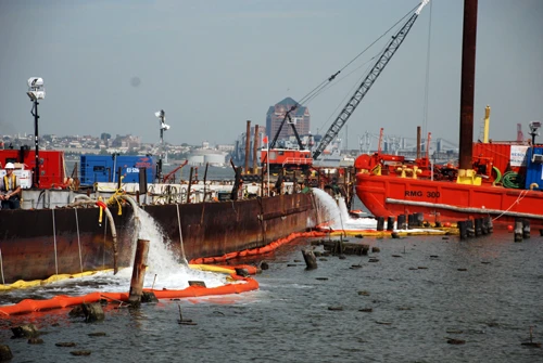 A rusty ship dumps water from two spouts