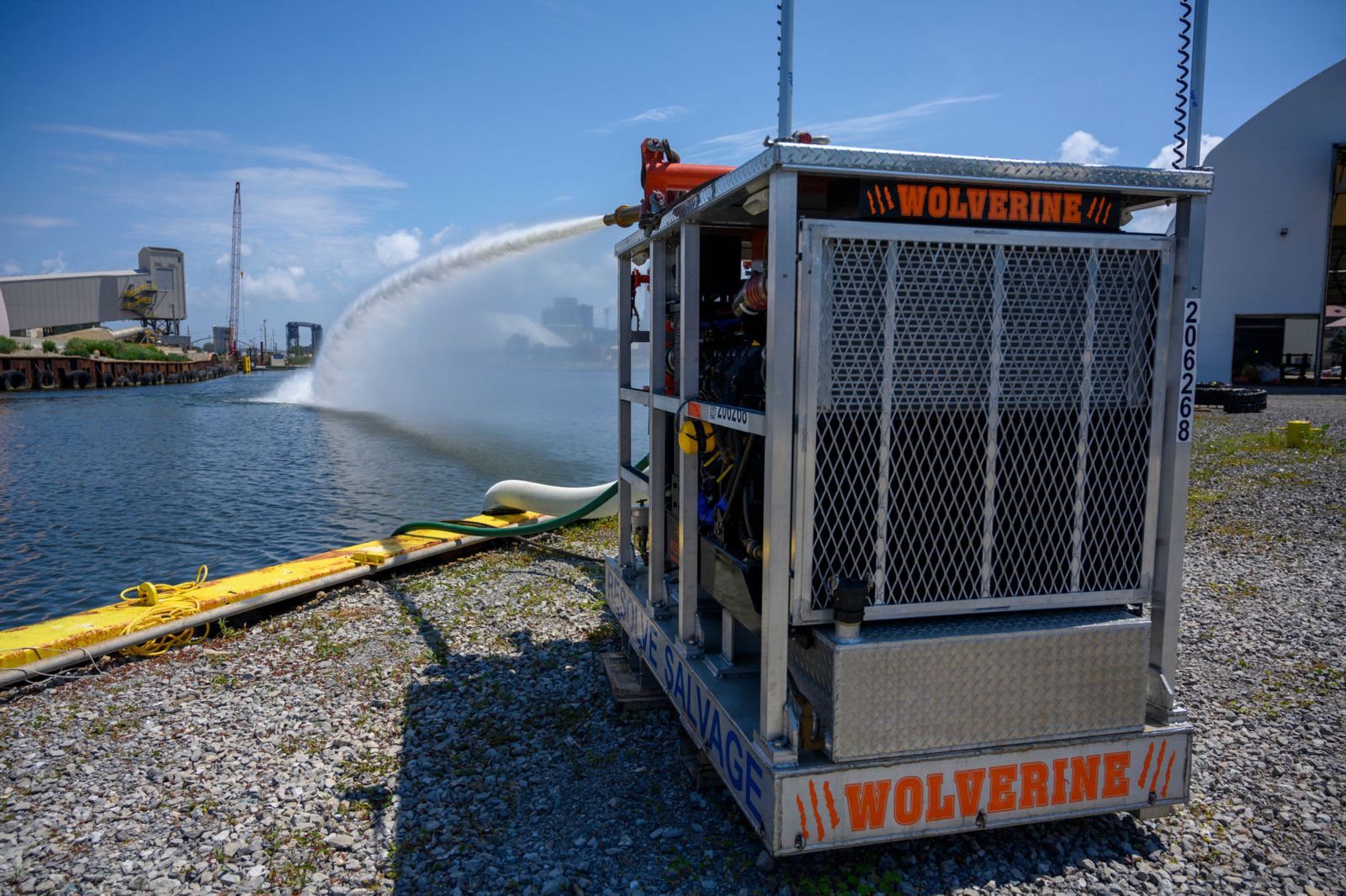 A high-pressure hose fires water from a metal container labeled Wolverine